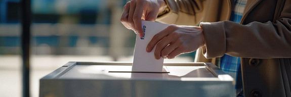 Woman Depositing Voting Ballot Into Ballot Box at Polling Statio